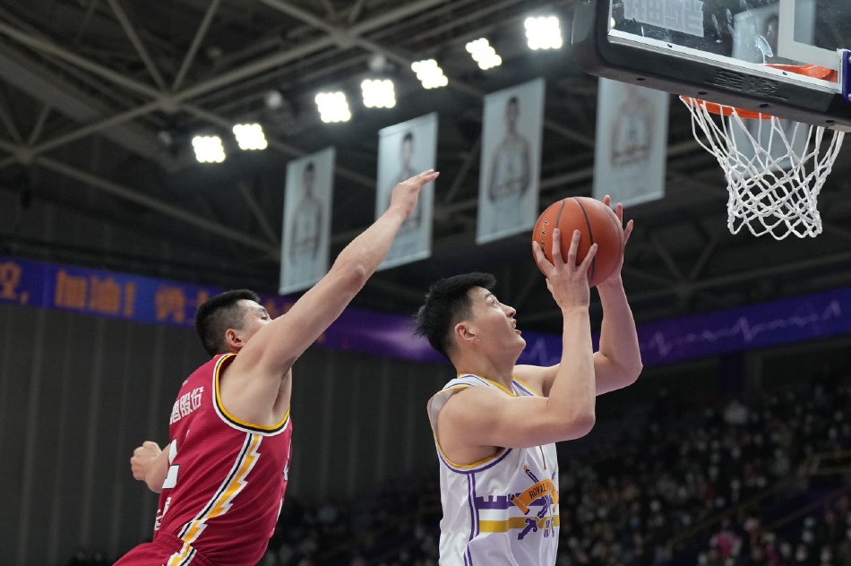 北控外援高登面对山西队的严防死守，眼神坚毅如铁，他熟练地运球穿越人墙，手臂肌肉线条分明，正准备在长人如林的禁区内强行上篮，为球队撕开一道得分缺口。