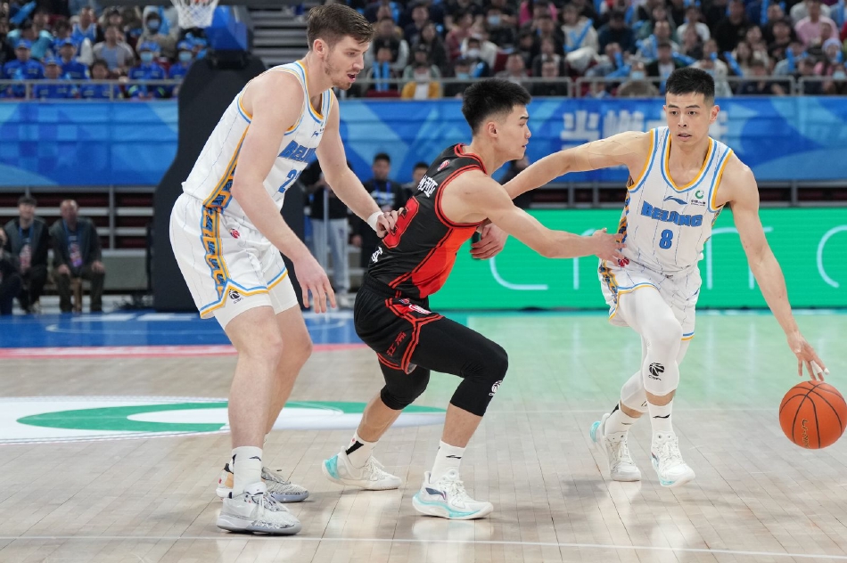 首钢队主教练在场边大声指挥，他的手势坚定有力，眼神中透露出对比赛的专注和对胜利的执着，运筹帷幄之中，决胜千里之外。