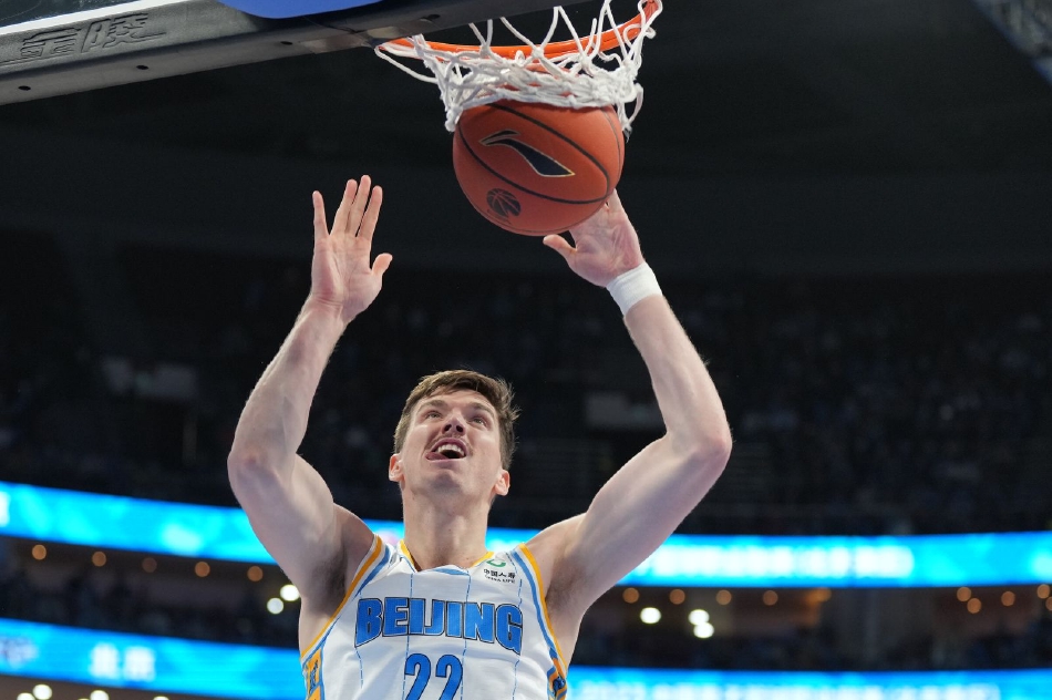 北京首钢队的小将曾凡博在完成一次精彩的扣篮后，与队友撞胸激情庆祝，他年轻的面庞上洋溢着自信与喜悦，这一刻属于他，也属于整个北京队。