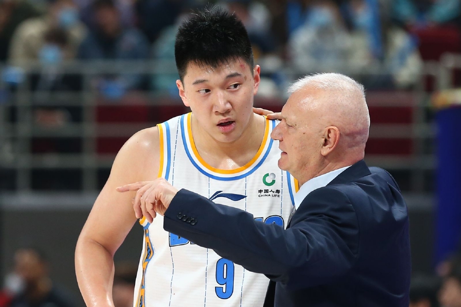 山东高速队球员兰兹博格在严密防守下强行突破上篮，身体在空中舒展，试图以一己之力撕开北京首钢的防线