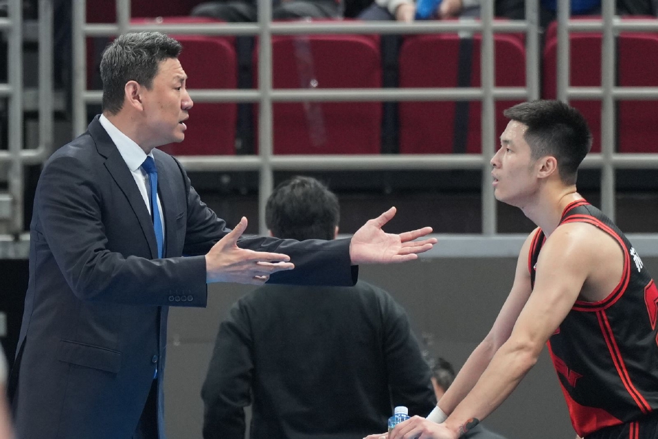 首钢队替补席在球员命中关键球后瞬间沸腾，大家挥舞着毛巾，脸上洋溢着兴奋的笑容，体现了球队内部良好的化学反应和团队氛围。