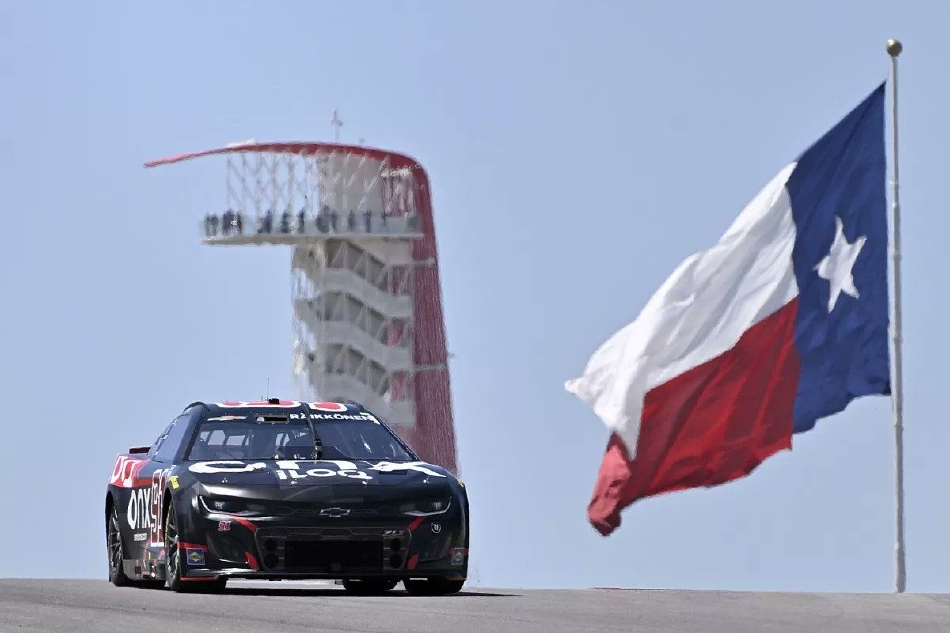 91号赛车在弯道中与对手并驾齐驱,车身紧贴赛道边缘,扬起的尘土与流畅的车身线条共同勾勒出纳斯卡比赛特有的力量与速度感。