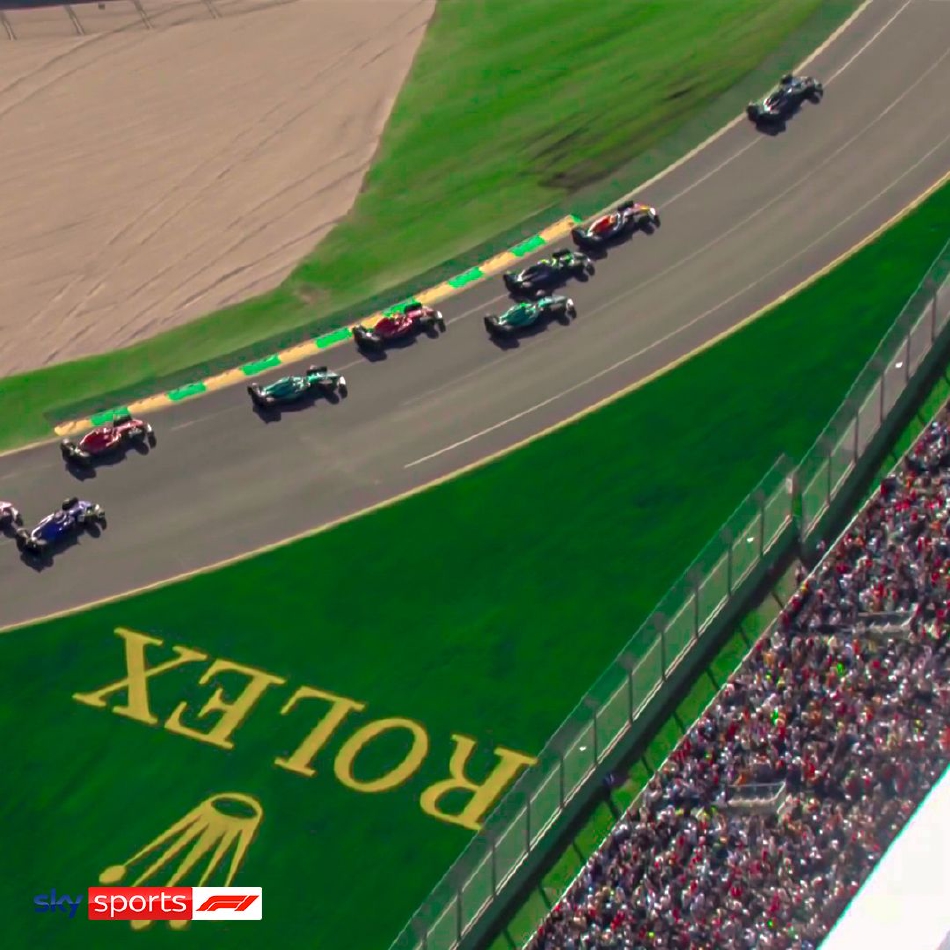 赛车疾驰而过,背景是墨尔本城市的天际线与静谧的湖面,现代科技的速度美学与自然风景形成强烈对比。