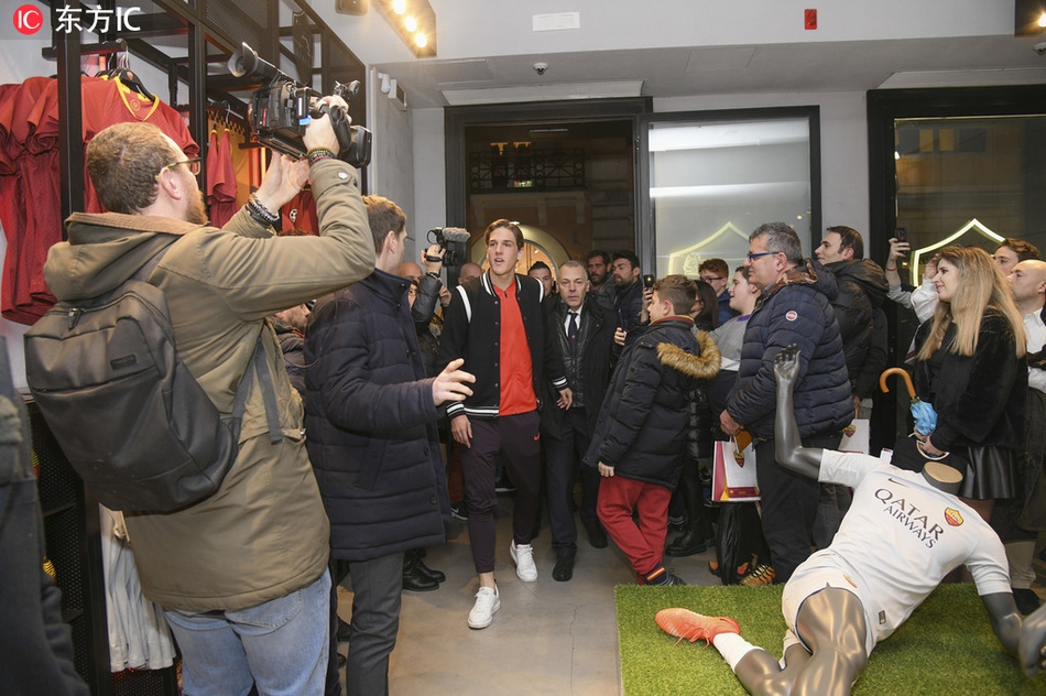 扎尼奥洛手持罗马围巾与美女球迷亲密合影，脸上洋溢着被簇拥的幸福与羞涩