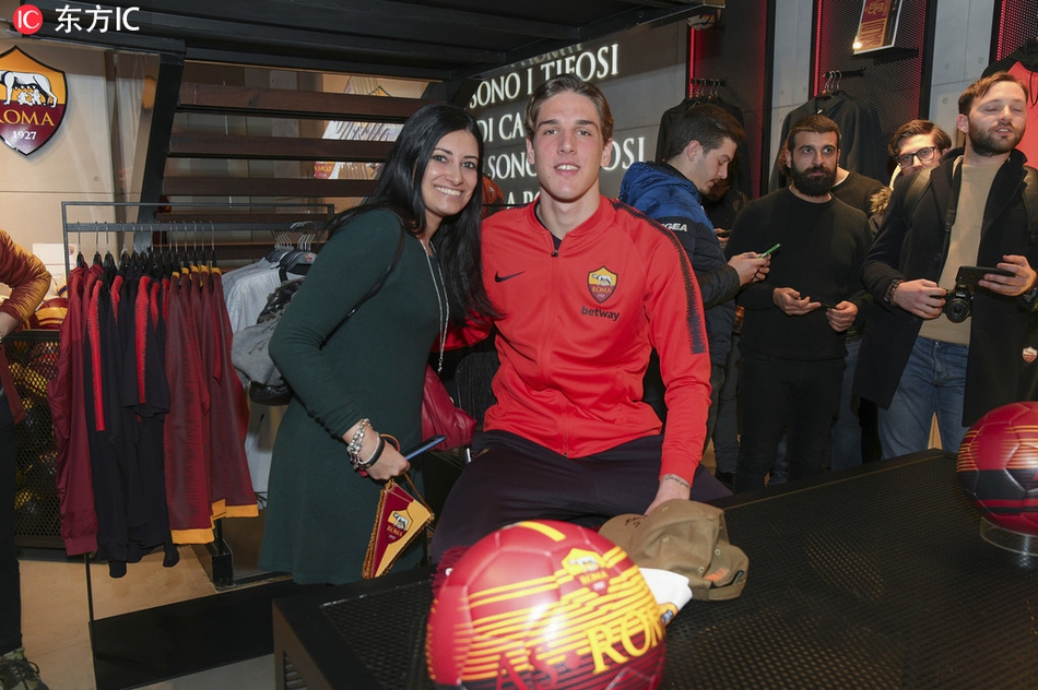 金发少年扎尼奥洛笑容灿烂，左右两侧美女球迷环绕，定格罗马城初见时的宠爱瞬间