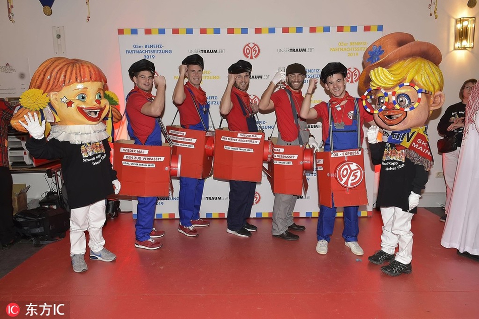 恐龙战队霸王龙战士与超级玛丽展开趣味拔河比赛，周围观众呐喊助威，场面热闹非凡。