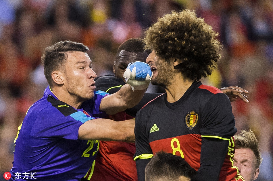 费莱尼身披比利时国家队战袍，在比赛中用胸部优雅地停球，随即准备发动长传，巨大的球衣号码下是他充满力量的身躯