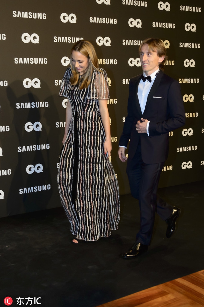 莫德里奇夫妇与到场的好友及嘉宾亲切交谈，他一身剪裁得体的深色西装显得风度翩翩，妻子则手持精致手包，侧耳倾听，举止优雅大方，完美展现了足坛模范夫妻的社交风采。