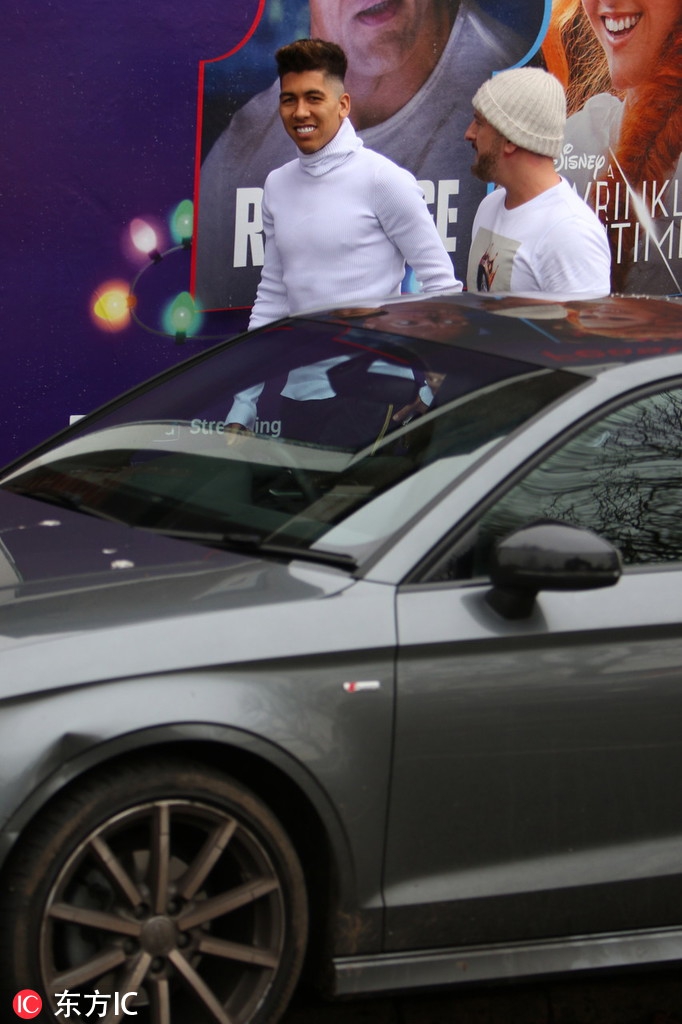 理发师精心修剪着发丝，菲尔米诺则放松地靠在椅背上，白色毛衣的柔软质感与他专注的侧脸形成一幅安详静谧的画面。