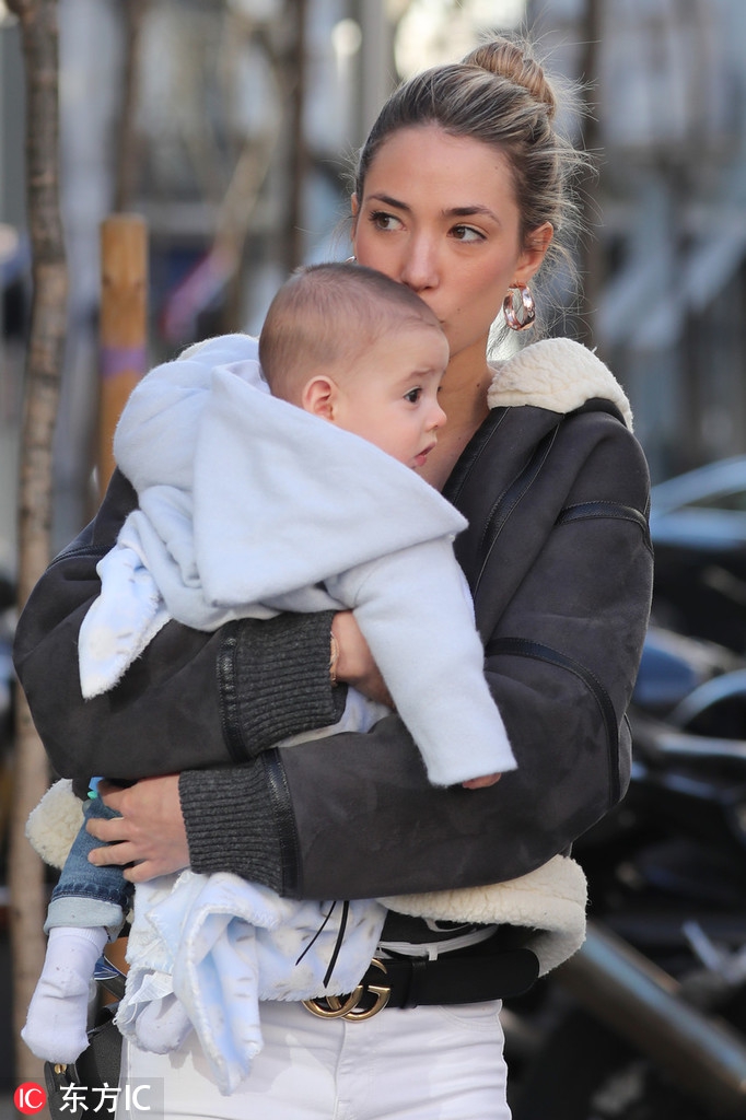 爱丽丝独自推着婴儿车走在马德里街头，她面带微笑，身形高挑纤细，即便在遛娃时也散发着时尚魅力。