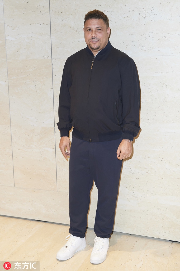 活动现场的罗纳尔多身穿休闲西装，整理衣领时面露微笑，整体状态轻松惬意。