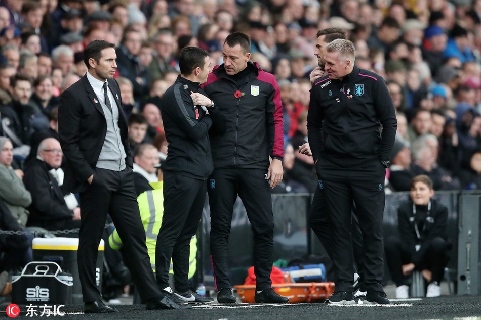 开球前，两位少帅在边线区域亲切攀谈，兰帕德微微侧身倾听，特里则面带微笑专注地讲述着什么。阳光洒在他们身上，昔日的战友如今虽各为其主，但情谊丝毫未减。