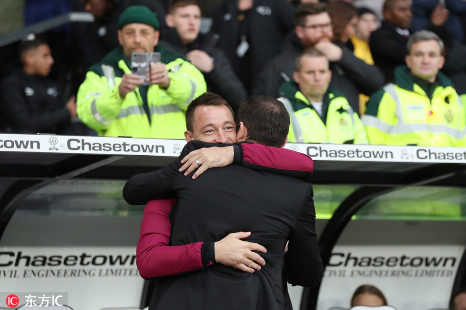 镜头捕捉到赛前瞬间，身披大衣的兰帕德与西装革履的特里在球员通道内相遇，两人脸上洋溢着重逢的喜悦，紧紧握手致意，仿佛时间倒流回斯坦福桥的更衣室。