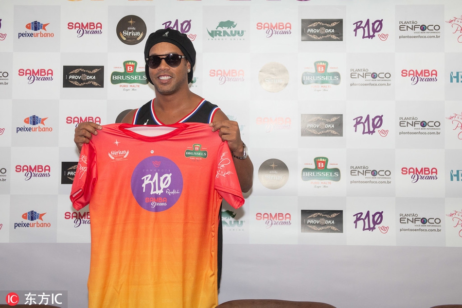 小罗做出一个即将亲吻足球的动作，眼睛笑得眯成一条缝，紫金色的湖人球衣与红白相间的足球构成一幅充满活力的画面，传递着足球带来的最纯粹的快乐