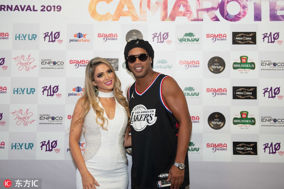 夜幕降临，里约狂欢节的灯光照亮小罗的背影，他穿着湖人球衣挥手告别，背景是模糊而璀璨的人潮，这个画面定格了传奇球星在家乡留下的又一个温暖瞬间