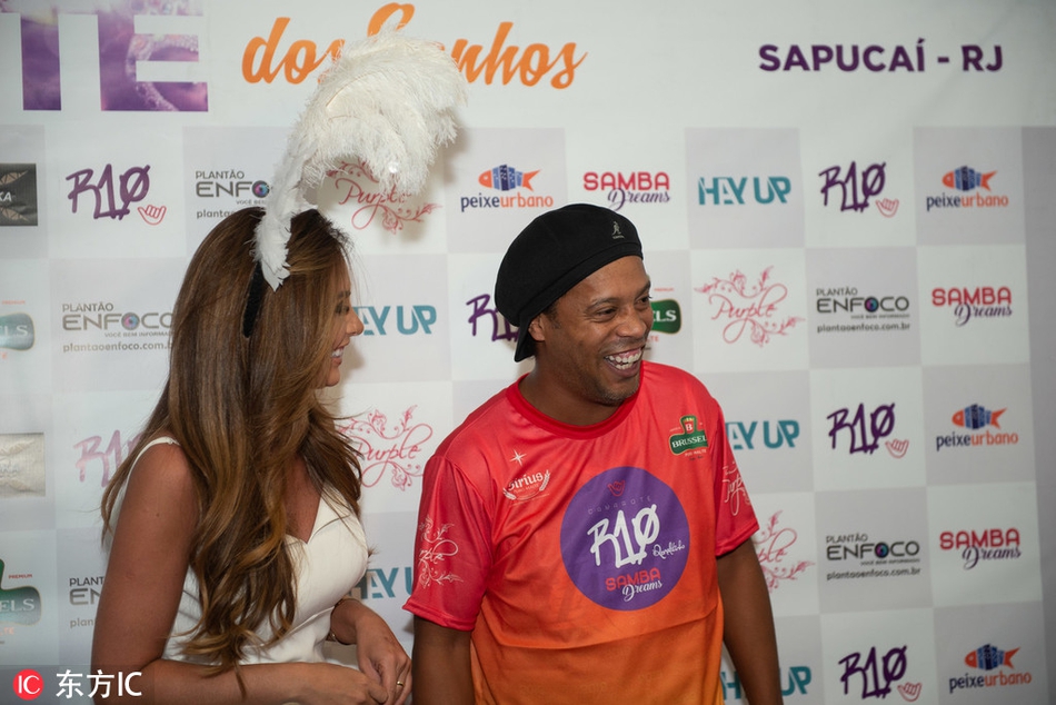 小罗在狂欢节人群中即兴展示足球技巧，他用脚后跟将球挑起，身体随着桑巴节奏轻轻摆动，湖人球衣的下摆也随之飘动，仿佛足球与篮球的韵律在此刻合二为一