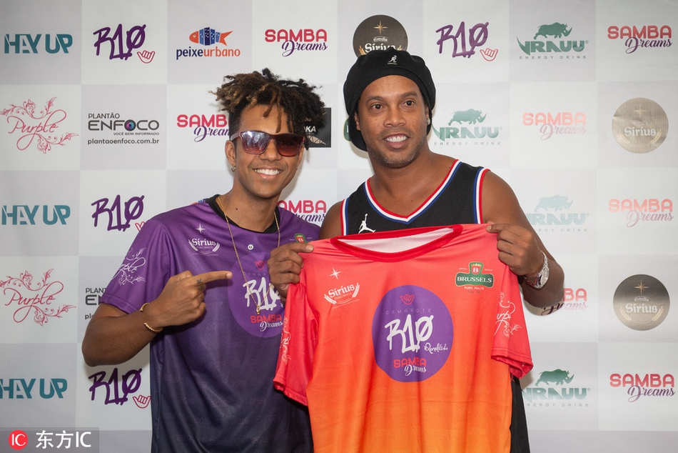 小罗背对镜头做出一个经典的踩单车动作，身体重心变幻莫测，对面穿着亮片舞裙的桑巴舞者瞬间变成了被过掉的‘防守球员’，整个画面充满了欢乐的戏剧感