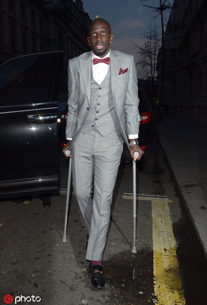 尽管拄着双拐，萨科齐的衣着依然考究，但这精致的外表掩盖不住他内心的焦虑。他正在与人交谈，但紧绷的面部肌肉和深锁的眉头出卖了他的真实情绪。