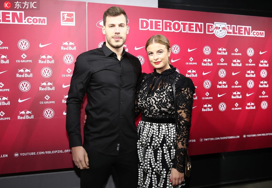 哈尔斯滕伯格与坎普尔正在合作装饰一个巨大的圣诞花环，两人脸上挂着专注又愉快的表情。