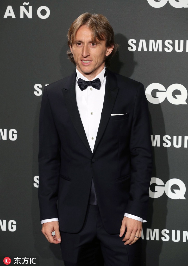 在颁奖典礼的后台，莫德里奇手持GQ年度体育人物奖杯，妻子博斯尼奇温柔地靠在他的肩头，奖杯的光泽映衬着两人幸福的笑容，定格下事业与爱情双丰收的温馨瞬间。