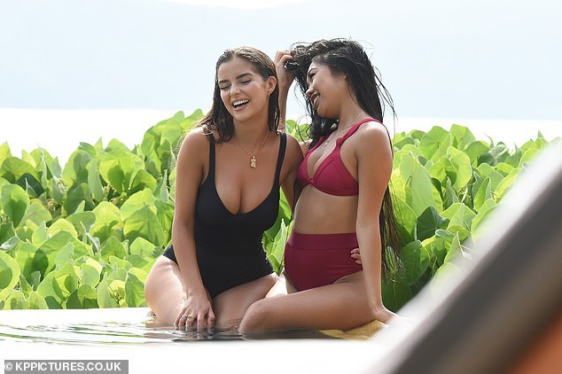 德米罗斯躺在沙滩上，用手轻遮阳光，黑色泳装与身下的白色沙粒形成鲜明对比，画面充满惬意与高级感。