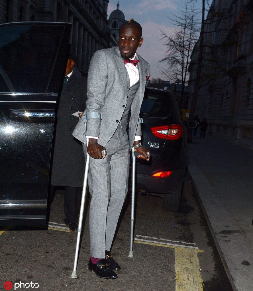 法国前总统萨科齐拄着双拐出现在晚宴红毯上，他身穿笔挺西装却难掩病容，紧皱的双眉透露出内心的沉重与不安。