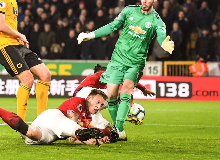 赛场上的菲尔·琼斯摔倒后抬头，脸上沾满草屑，表情既痛苦又迷茫，生动展现了他的狼狈与拼劲