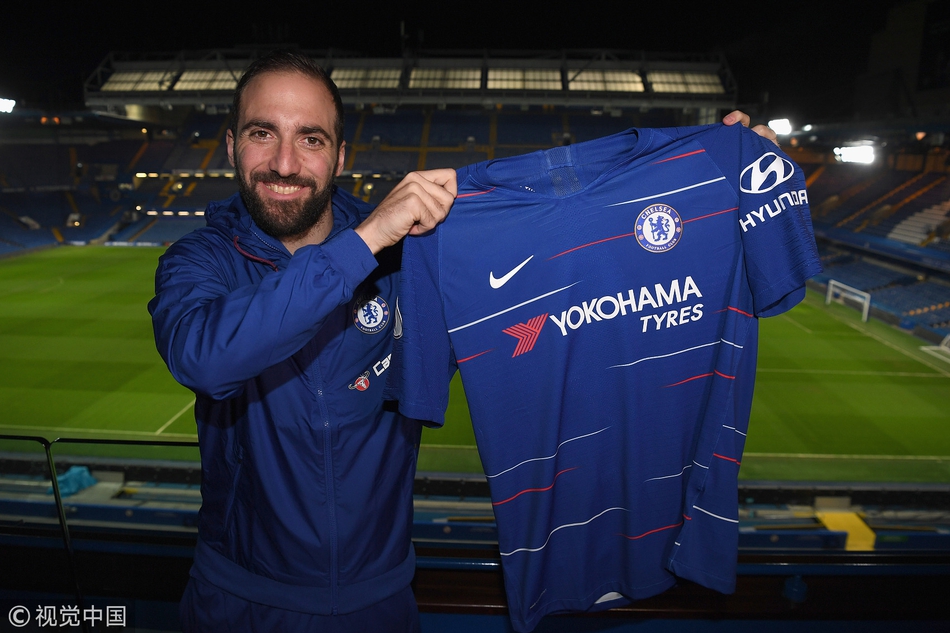 伊瓜因面带微笑，在切尔西队徽前手举9号球衣，正式亮相斯坦福桥。