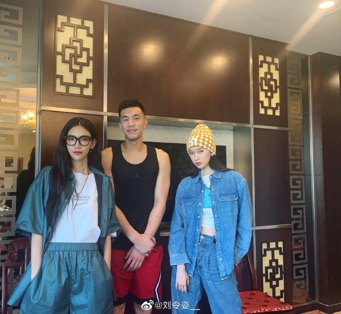 众人合影中，郭艾伦站在C位略显拘谨，双手抱在身前，两位小姐姐对着镜头比出可爱手势