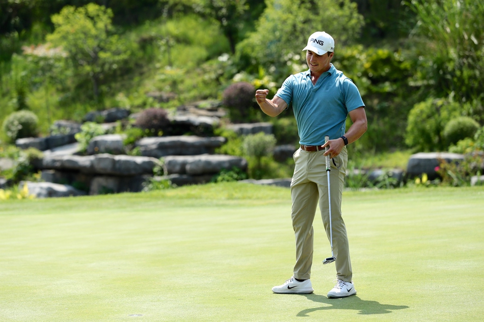 颁奖典礼上，查利·萨克森从嘉宾手中接过象征胜利的冠军奖杯，笑容满面。