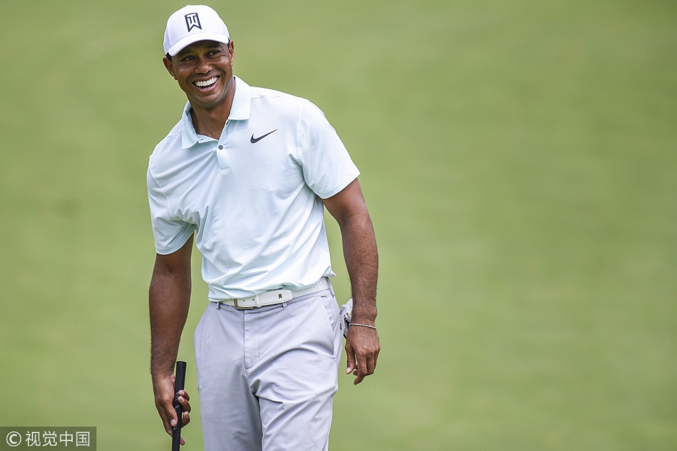 泰格·伍兹凝神注视果岭，阳光勾勒出他坚毅的侧脸轮廓