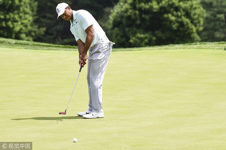 夕阳下伍兹独自走过球道，身影坚毅而专注，仿佛承载着高尔夫的历史与未来