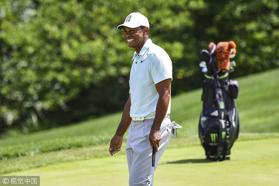 伍兹与球童深入探讨攻果岭策略，两人手指远方，展现团队协作的默契时刻