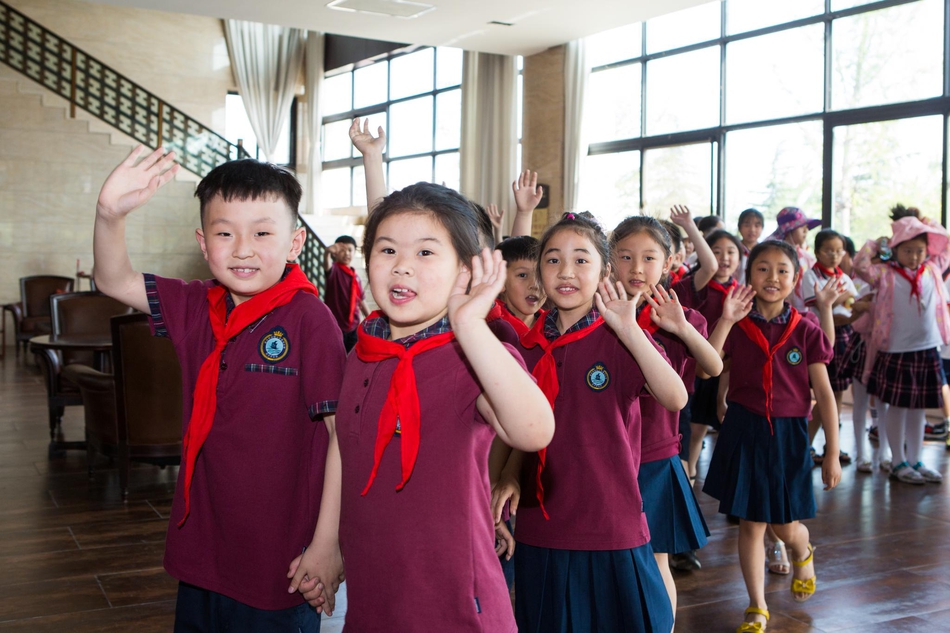 高尔夫前辈马万里先生在台上分享,他手势有力,神情专注,台下坐满了聚精会神的青少年球员和家长们,墙上投影着‘梦想与坚持’的主题画面