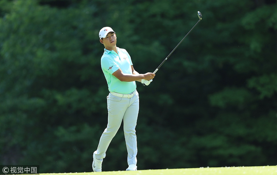 球员在缪菲尔德村庄高尔夫俱乐部的球道上漫步前行，阳光将他们的身影拉长，与翠绿的草地构成一幅宁静而充满张力的画面。