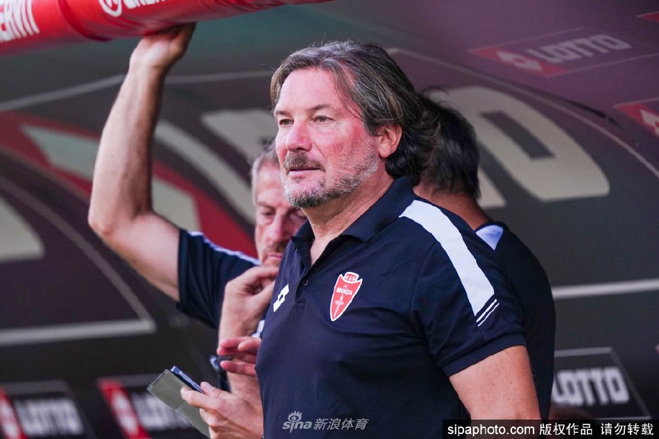 前蒙扎主帅斯特罗帕在场边神情专注地指挥比赛，眉头微蹙思考着战术