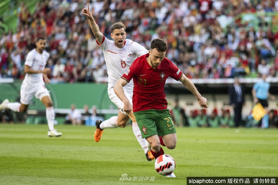 若塔在过往比赛中痛苦倒地手捂小腿，表情充满了不甘与无奈，背景是模糊的绿茵场与对手。