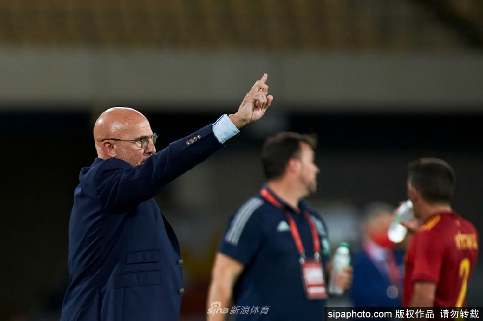 西班牙队世界杯出局后球员们神情落寞，与背景中对手的欢庆形成鲜明对比，预示着一个时代的结果