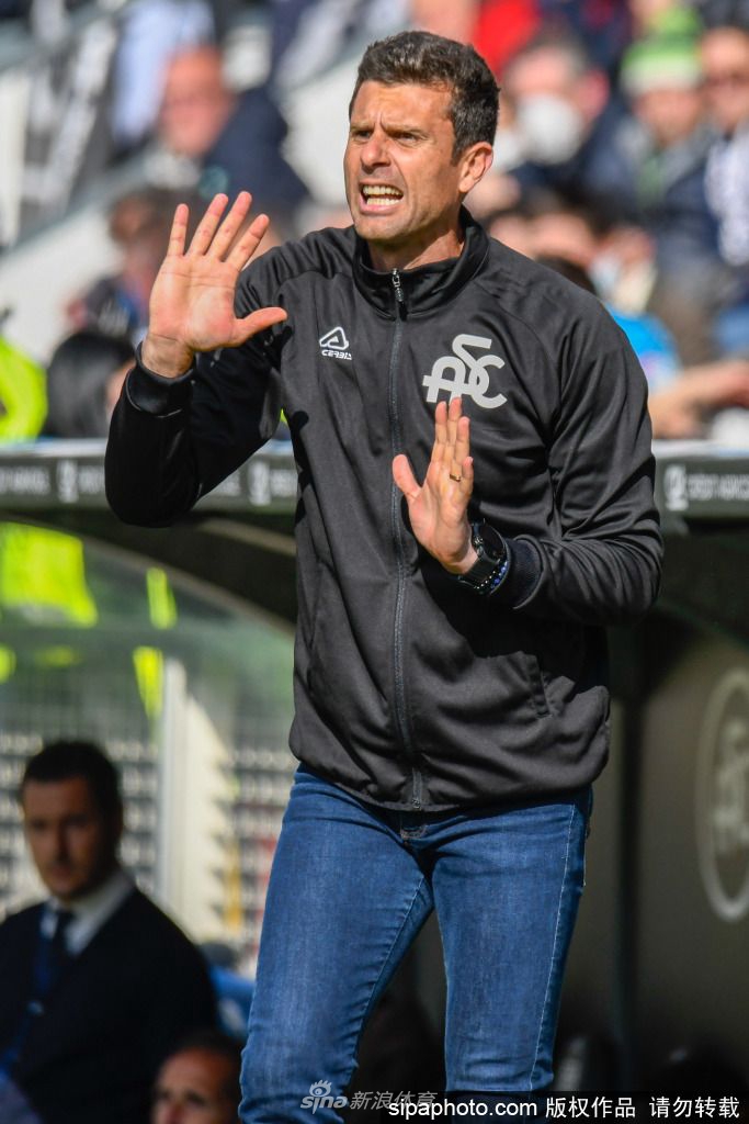 蒂亚戈·莫塔在训练场边全神贯注地指导球员，表情认真而投入，展现出少帅的专注与激情。