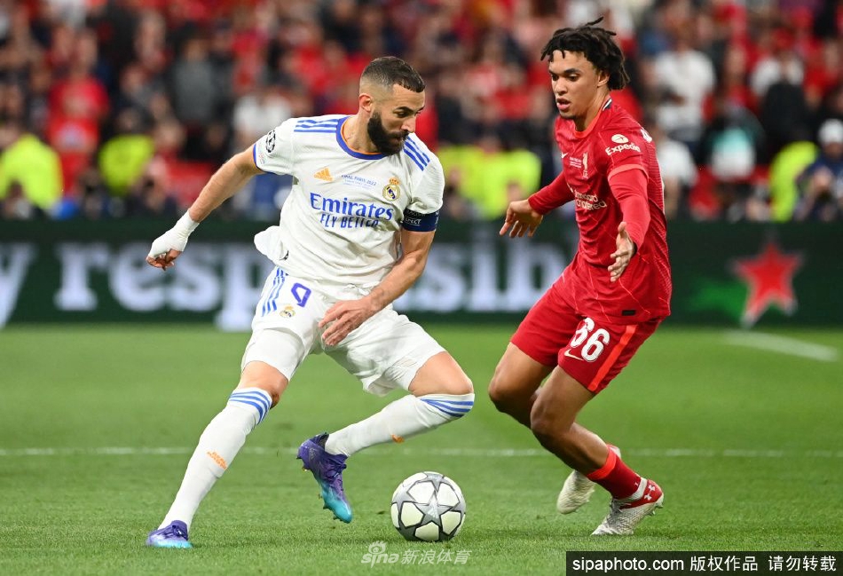 本泽马身着优雅正装，在颁奖典礼的舞台上与奖杯合影，聚光灯下的他尽显王者风范