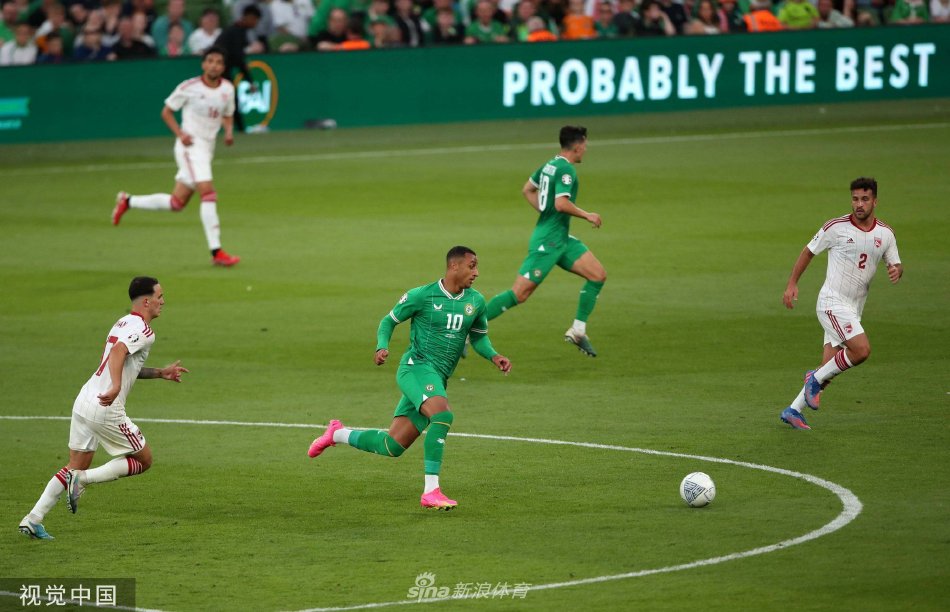 爱尔兰队球员围拢在一起激情庆祝进球，替补席上的队员也冲入场内，喜悦之情溢于言表。