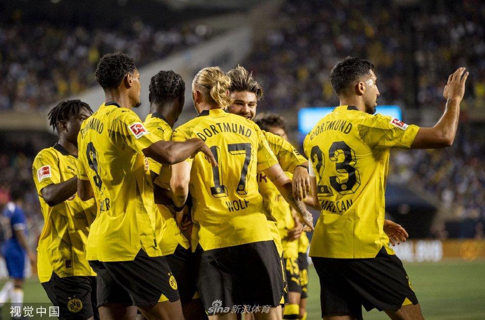 切尔西前锋带球突破多特蒙德后卫防守，球场灯光照亮他坚定的侧脸与飞扬的草屑