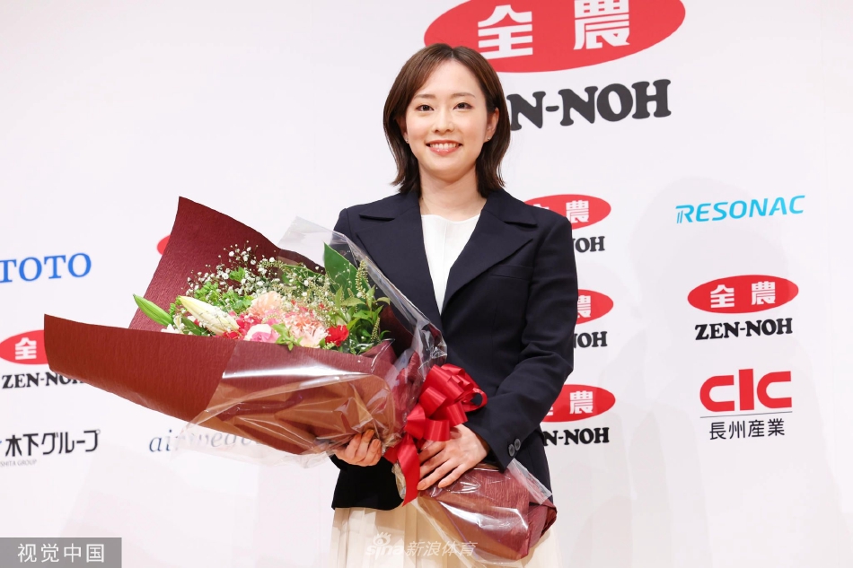 石川佳纯双手紧握放在面前，神情专注地倾听记者提问，耳边的耳钉闪烁着低调的光泽，举手投足间流露出成熟女性的知性美与优雅气质