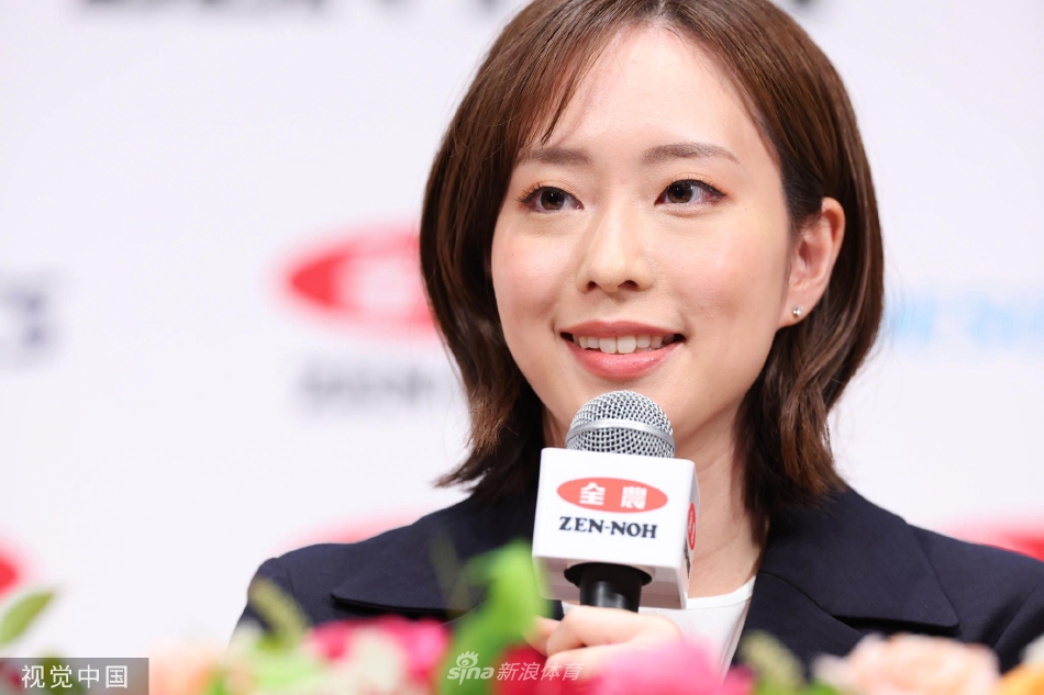 面对台下的媒体和粉丝，石川佳纯微微侧身低头，似乎在整理思绪，桌上摆放的名牌与话筒见证着她从赛场斗士到成熟女性的身份转变