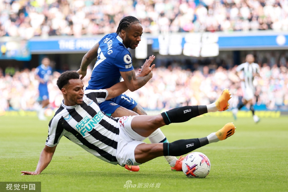 切尔西球员斯特林与纽卡斯尔联队球员特里皮尔在边线附近激烈拼抢，足球就在两人脚边。