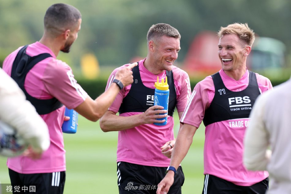 两名球员快乐击掌庆祝训练中精彩配合，笑容灿烂传递团队信心