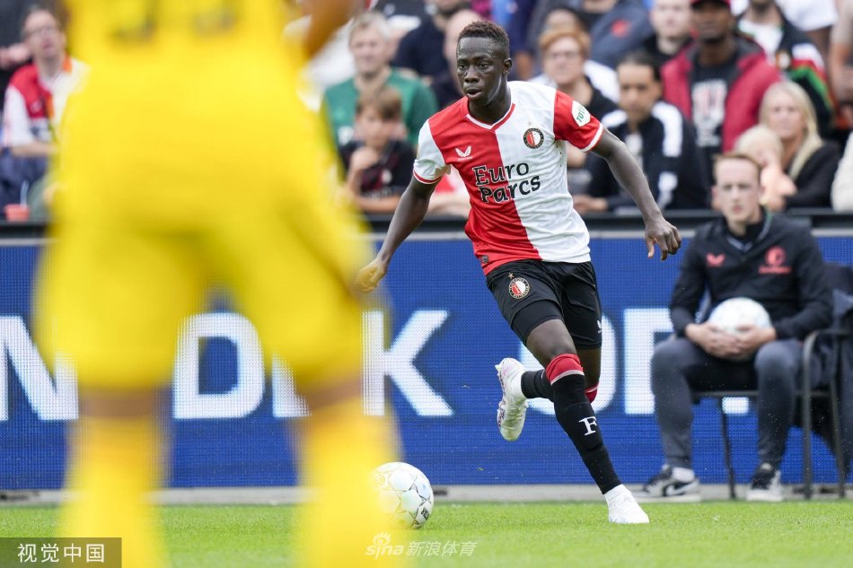 费耶诺德球员攻入制胜球后狂奔庆祝，张开双臂拥抱夏夜晚风，身后是激动万分纷纷跃起的队友与看台上已成欢庆海洋的红色浪潮。