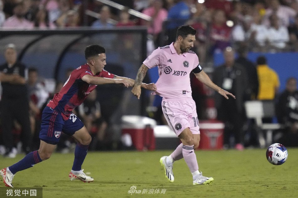 梅西与对手激烈拼抢，在两名防守球员的包夹中依然牢牢护住皮球，尽显大师级的控球与平衡能力。