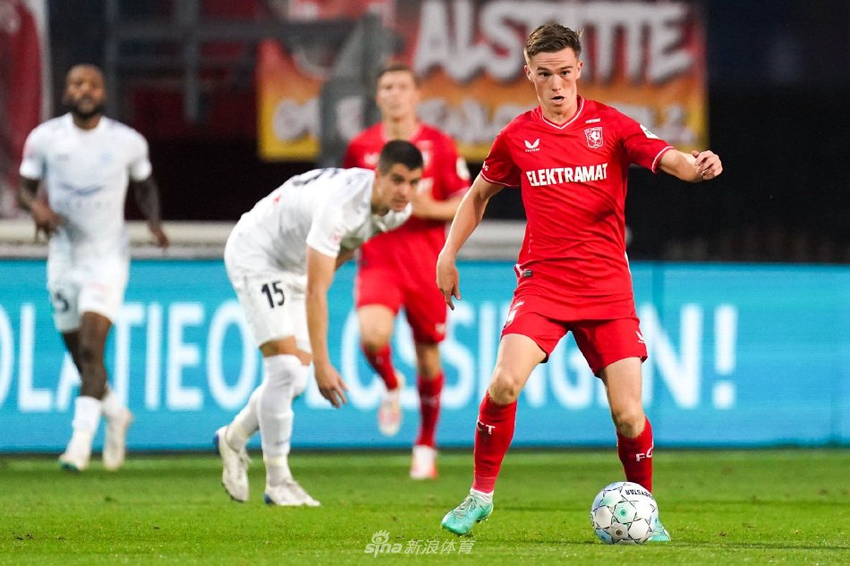 特温特球员进球后狂奔庆祝，与队友紧紧相拥，背景是看台上沸腾的橙色海洋与漫天挥动的旗帜