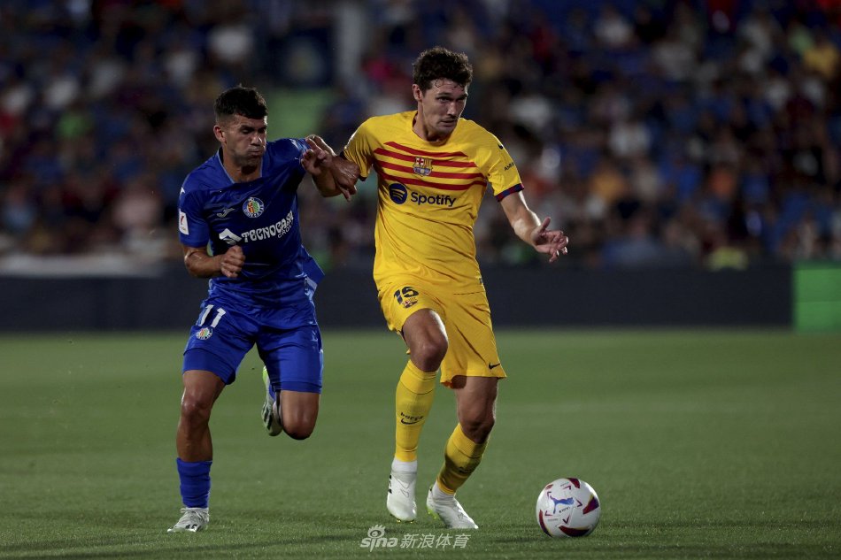 巴萨主帅哈维站在场边神情严肃指挥比赛，身后是喧嚣的赫塔费主场看台，气氛紧张而凝重。